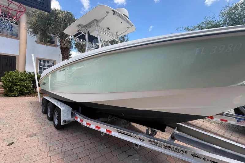 Slide: The Image of 2007 Boston Whaler 270 Outrage boat on trailer, parked in a driveway. - 13