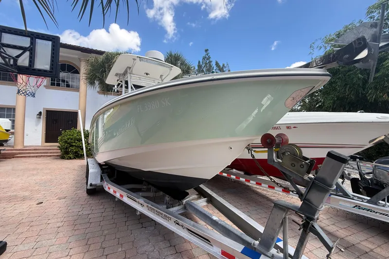 Slide: The Image of 2007 Boston Whaler 270 Outrage on trailer, parked in driveway under blue sky. - 15