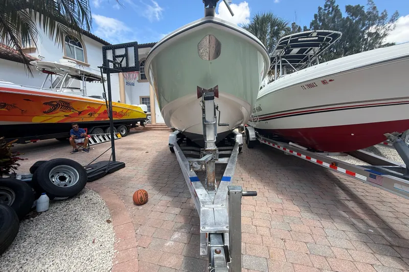 Slide: The Image of 2007 Boston Whaler 270 Outrage on trailer, surrounded by other boats and equipment. - 17