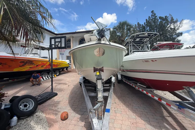 Slide: The Image of 2007 Boston Whaler 270 Outrage on trailer, surrounded by boats and palm trees. - 18