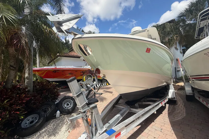 Slide: The Image of 2007 Boston Whaler 270 Outrage boat on trailer, surrounded by palm trees. - 19