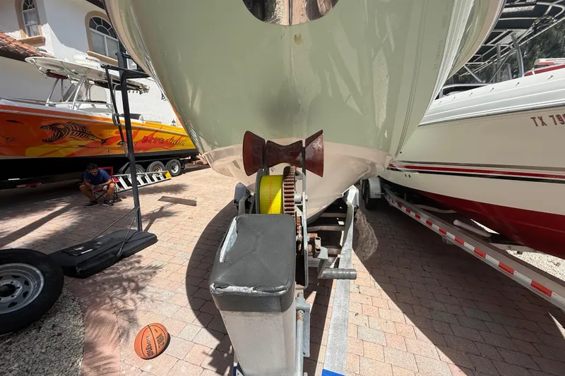 Slide: The Image of 2007 Boston Whaler 270 Outrage boat on trailer, parked beside other boats. - 22