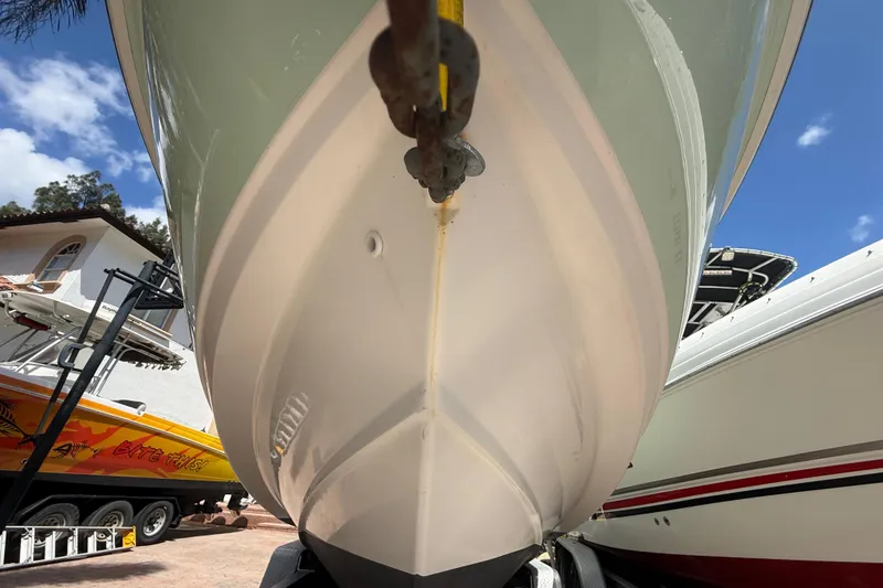 Slide: The Image of 2007 Boston Whaler 270 Outrage boat hull, parked outdoors under a clear blue sky. - 23