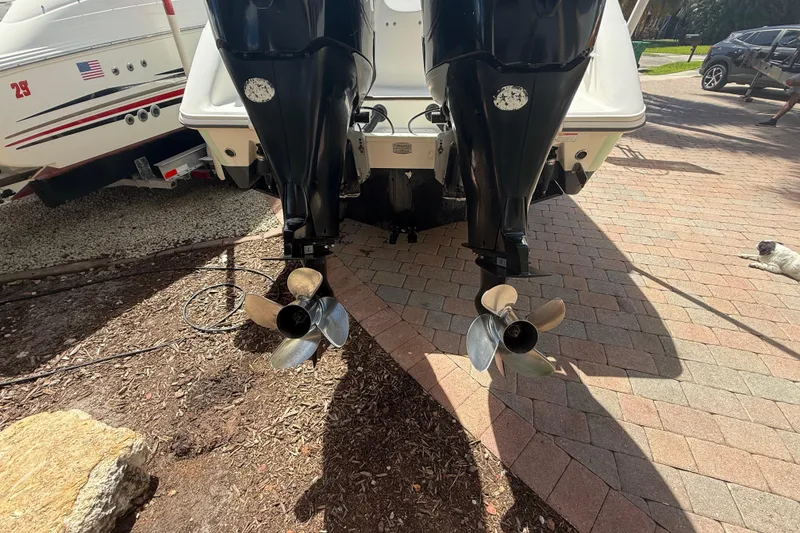 Slide: The Image of Twin outboard motors on a 2007 Boston Whaler 270 Outrage, parked on a brick driveway. - 25