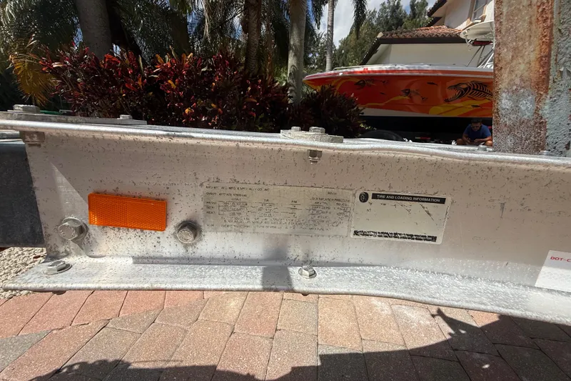 Slide: The Image of Trailer with tire and loading information, Boston Whaler 270 Outrage boat in background. - 30