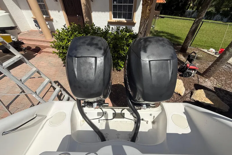Slide: The Image of Twin outboard motors on a 2007 Boston Whaler 270 Outrage boat, parked outdoors. - 44