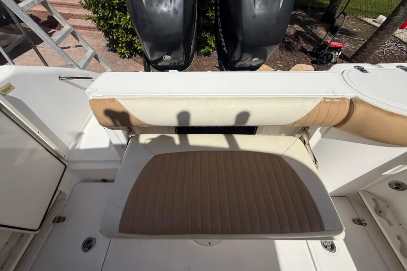 Slide: The Image of 2007 Boston Whaler 270 Outrage boat seating area with tan cushions and dual outboard motors. - 46