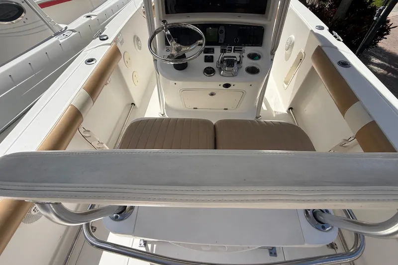 Slide: The Image of 2007 Boston Whaler 270 Outrage helm with steering wheel and controls, featuring beige seating. - 51