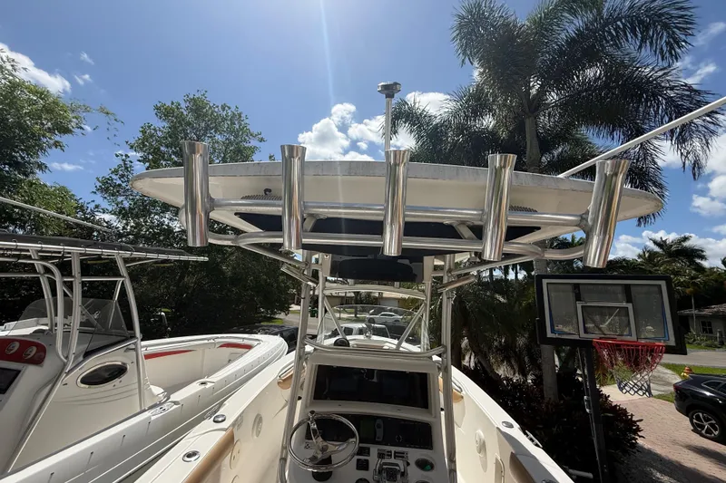 Slide: The Image of 2007 Boston Whaler 270 Outrage boat with T-top and rod holders, parked outdoors. - 55