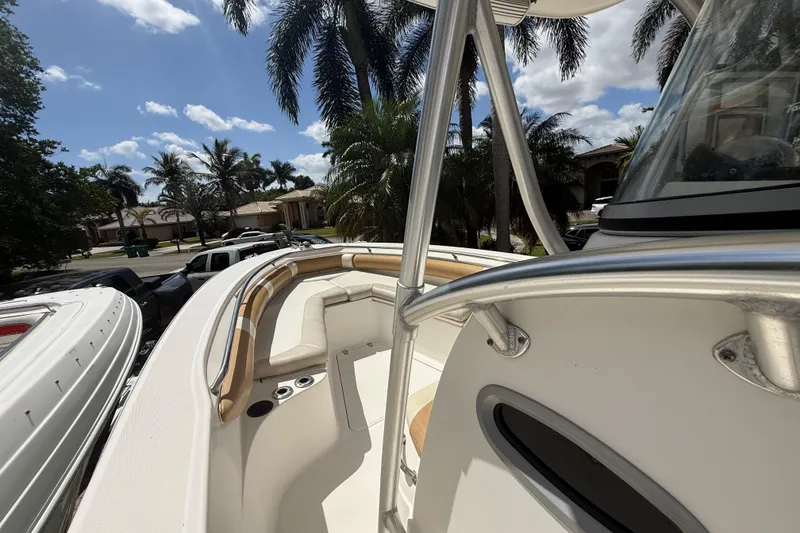 Slide: The Image of 2007 Boston Whaler 270 Outrage boat with seating, palm trees, and blue sky background. - 58