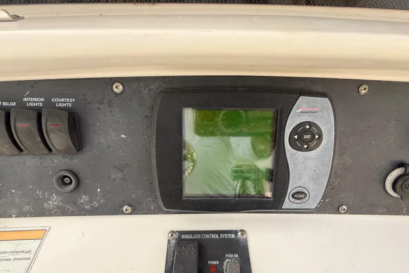 Slide: The Image of Control panel of a 2007 Boston Whaler 270 Outrage boat with switches and display. - 65