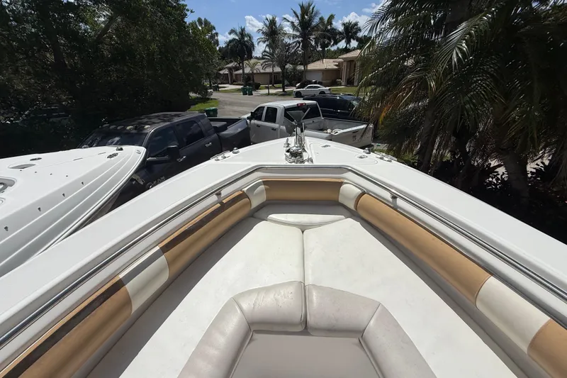 Slide: The Image of 2007 Boston Whaler 270 Outrage boat with cushioned seating, parked near palm trees. - 75