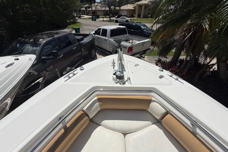 Slide: The Image of Bow view of 2007 Boston Whaler 270 Outrage, parked near trucks and palm trees. - 76