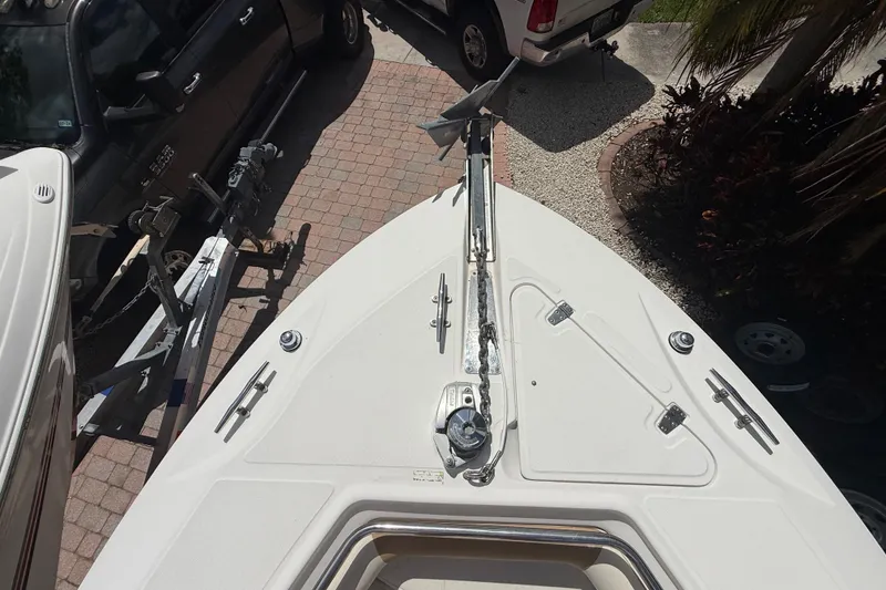 Slide: The Image of 2007 Boston Whaler 270 Outrage boat bow with anchor, parked near vehicles. - 77