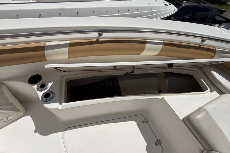 Slide: The Image of 2007 Boston Whaler 270 Outrage boat interior with open storage compartment and cup holders. - 79