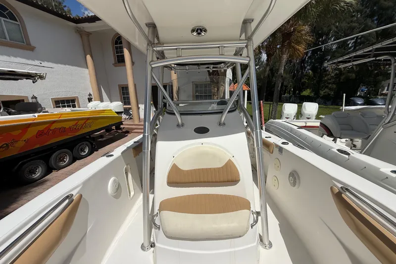 Slide: The Image of 2007 Boston Whaler 270 Outrage boat interior with seating and console, parked near a house. - 83