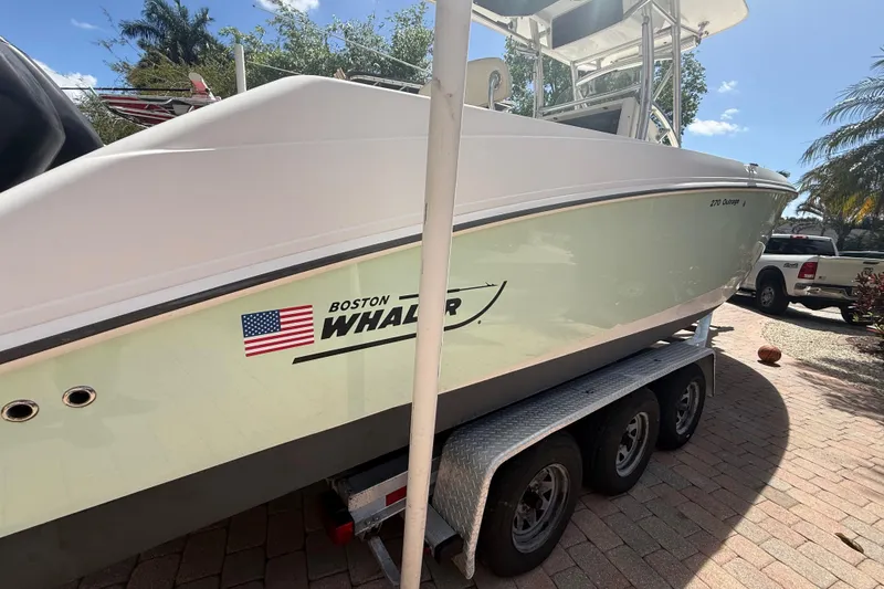 Slide: The Image of 2007 Boston Whaler 270 Outrage boat on trailer, parked outdoors. - 9