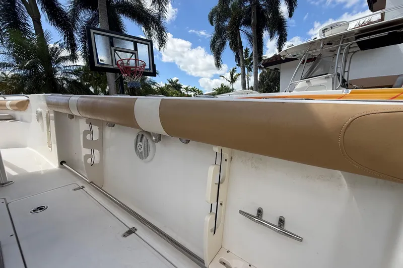 Slide: The Image of 2007 Boston Whaler 270 Outrage boat interior with tan upholstery, palm trees, and basketball hoop. - 93