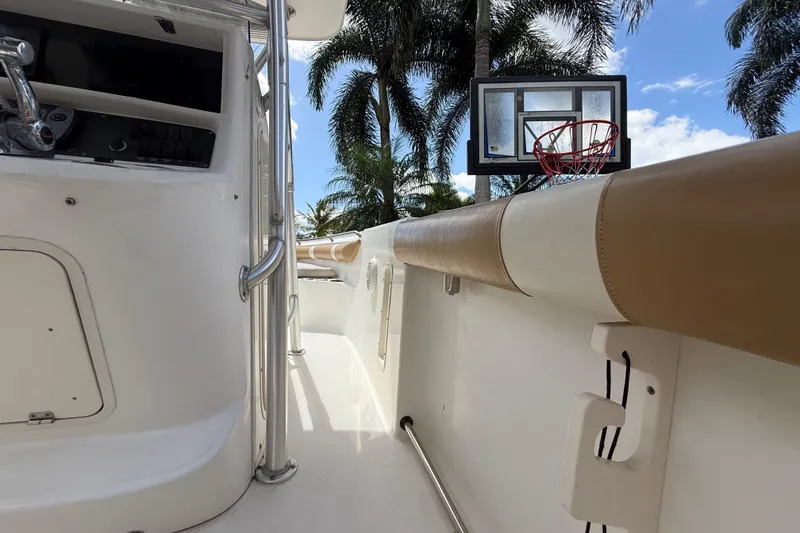 Slide: The Image of 2007 Boston Whaler 270 Outrage interior with palm trees and basketball hoop in background. - 95