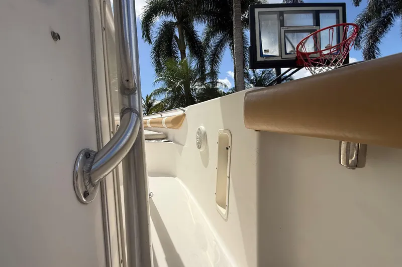 Slide: The Image of 2007 Boston Whaler 270 Outrage boat interior with palm trees and basketball hoop in background. - 96
