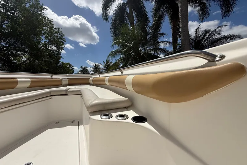 Slide: The Image of 2007 Boston Whaler 270 Outrage boat interior with seating, palm trees, and blue sky. - 98