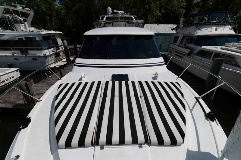 Slide: The Image of 1999 West Bay 58 Sonship Pilothouse MY on calm water, striped sunbed on deck. - 14