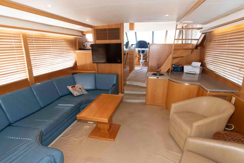 Slide: The Image of Luxurious interior of 1999 West Bay 58 Sonship Pilothouse MY with blue seating and wooden table. - 18