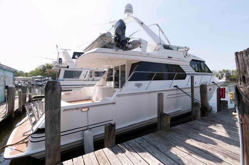 Slide: The Image of 1999 West Bay 58 Sonship Pilothouse MY yacht docked, showcasing sleek design and polished railings. - 2