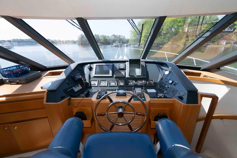 Slide: The Image of Pilothouse interior of 1999 West Bay 58 Sonship, featuring navigation controls and panoramic windows. - 25