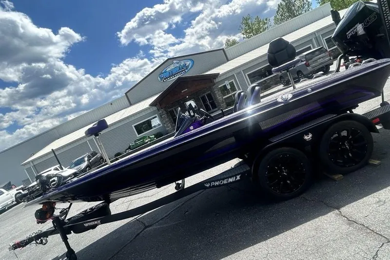 Slide: The Image of 2025 Phoenix 919 ZXL boat on trailer outside dealership under blue sky. - 23