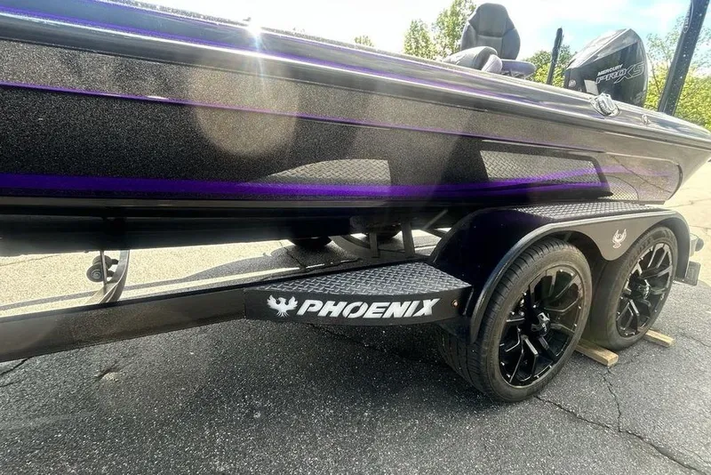 Slide: The Image of 2025 Phoenix 919 ZXL boat on trailer with black wheels and purple accents. - 27