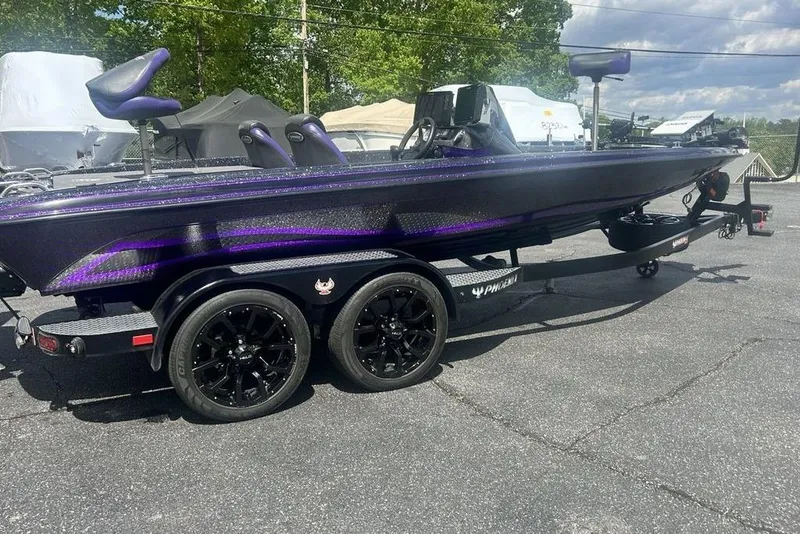 Slide: The Image of 2025 Phoenix 919 ZXL boat with sleek design and dual-axle trailer in outdoor setting. - 3