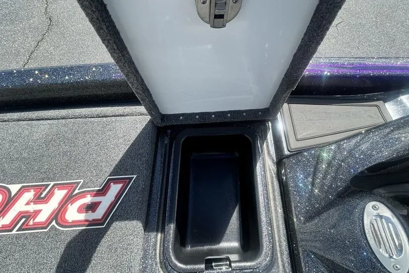 Slide: The Image of Open storage compartment in 2025 Phoenix 919 ZXL boat, featuring carpeted interior and sleek design. - 4