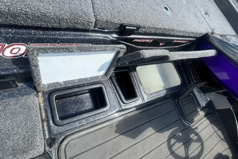 Slide: The Image of Interior of a 2025 Phoenix 919 ZXL boat showing storage compartments and carpeted surfaces. - 9