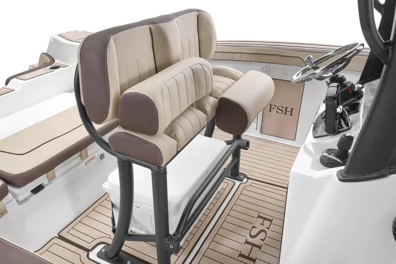 Slide: The Image of 2026 Yamaha Boats 255 FSH Sport E interior with beige seating and steering console. - 6
