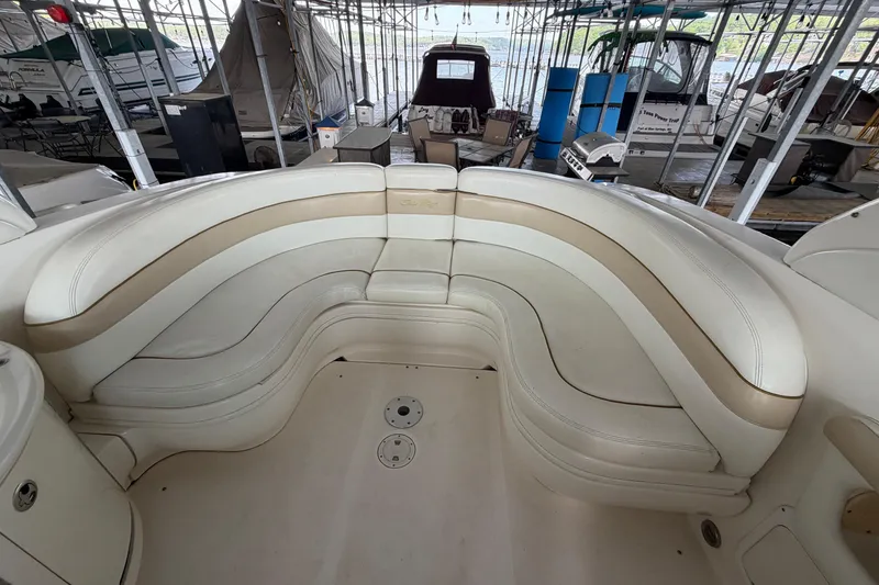 Slide: The Image of 2003 Sea Ray 290 Bow Rider with spacious, curved seating in a marina setting. - 11