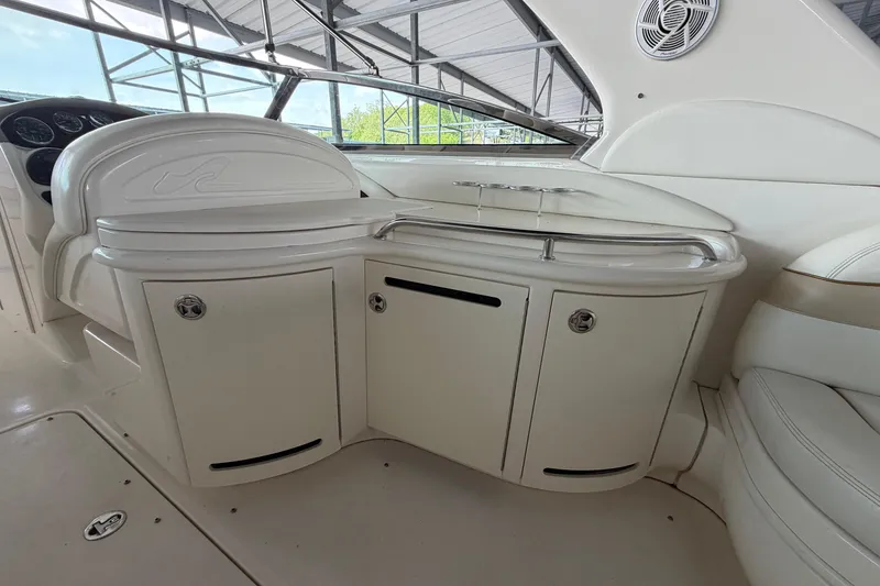 Slide: The Image of Interior of a 2003 Sea Ray 290 Bow Rider boat, featuring white cabinetry and seating. - 12