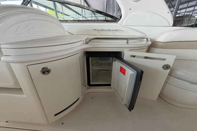 Slide: The Image of Open mini fridge on 2003 Sea Ray 290 Bow Rider boat, showcasing interior storage space. - 13