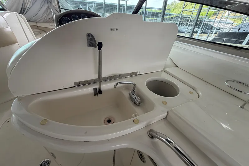 Slide: The Image of 2003 Sea Ray 290 Bow Rider boat sink and faucet in cockpit area. - 14