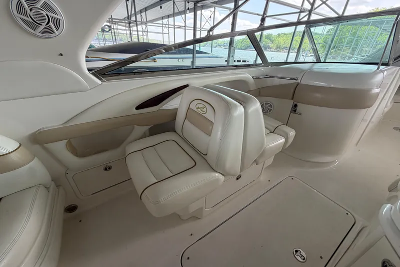 Slide: The Image of Interior of a 2003 Sea Ray 290 Bow Rider boat, featuring beige seating and sleek design. - 15