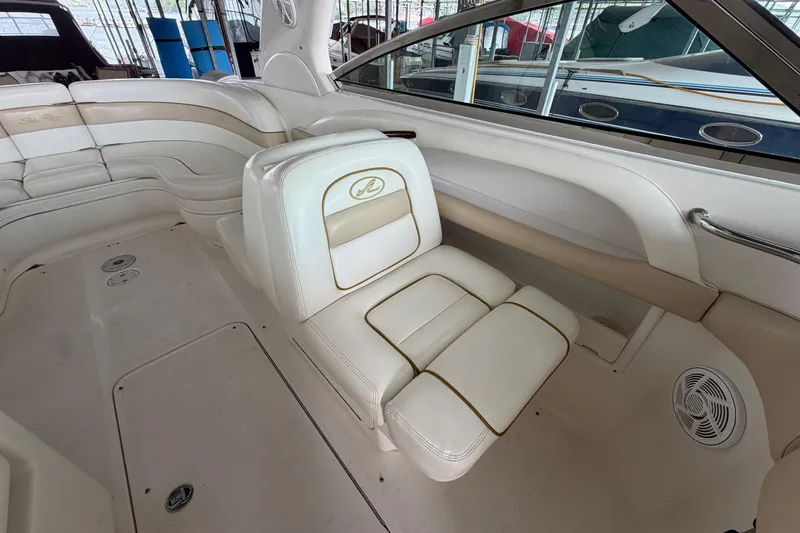 Slide: The Image of Interior of a 2003 Sea Ray 290 Bow Rider boat with white leather seating. - 16