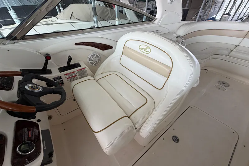 Slide: The Image of 2003 Sea Ray 290 Bow Rider cockpit with white leather seating and steering wheel. - 17