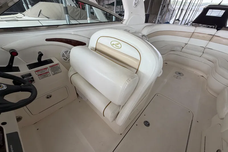 Slide: The Image of Interior of a 2003 Sea Ray 290 Bow Rider boat with white seating and controls. - 18