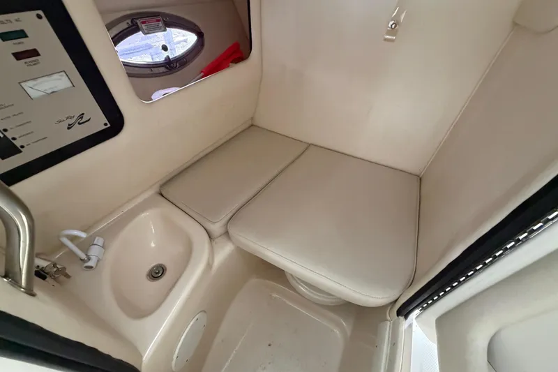 Slide: The Image of Interior of 2003 Sea Ray 290 Bow Rider boat with sink and cushioned seating. - 22