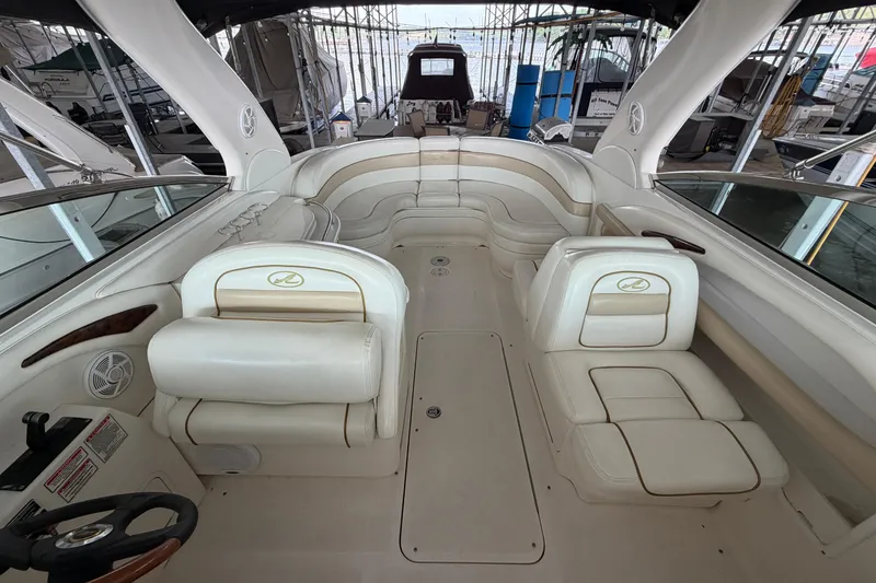 Slide: The Image of 2003 Sea Ray 290 Bow Rider interior with white leather seating and steering wheel. - 25