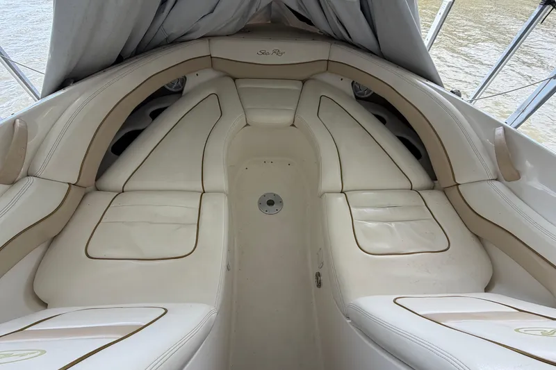 Slide: The Image of 2003 Sea Ray 290 Bow Rider interior with beige seating and water view. - 27