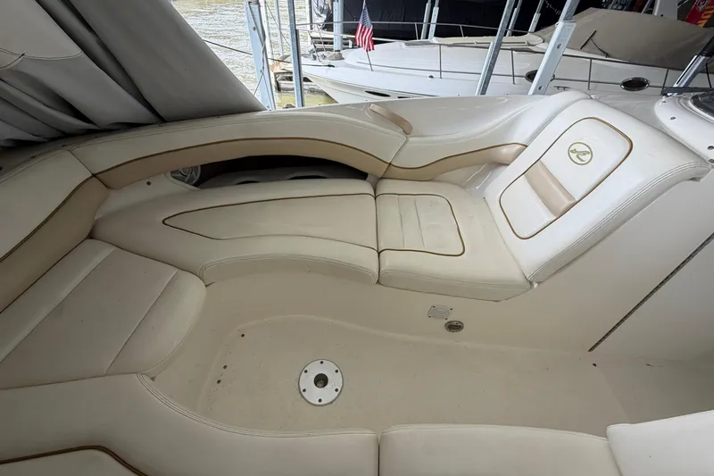 Slide: The Image of 2003 Sea Ray 290 Bow Rider interior with cream leather seating in a docked position. - 28