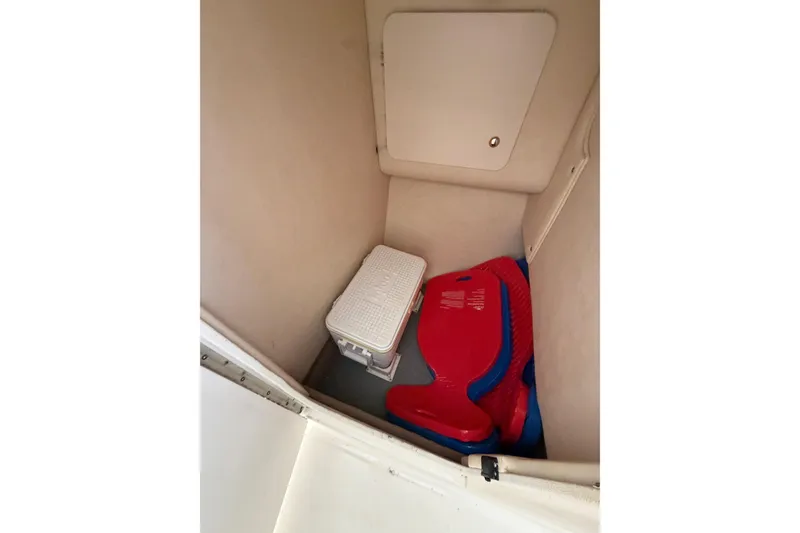 Slide: The Image of Interior storage compartment of 2003 Sea Ray 290 Bow Rider with cooler and life jackets. - 31