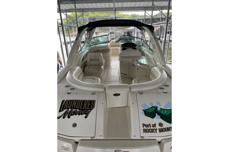 Slide: The Image of 2003 Sea Ray 290 Bow Rider boat docked, featuring spacious seating and custom graphics. - 5