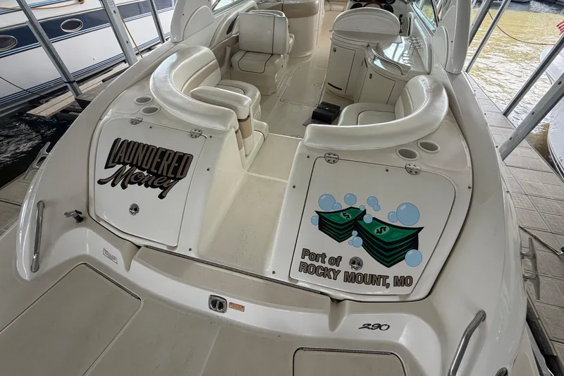 Slide: The Image of 2003 Sea Ray 290 Bow Rider boat docked, featuring custom graphics and spacious seating. - 6